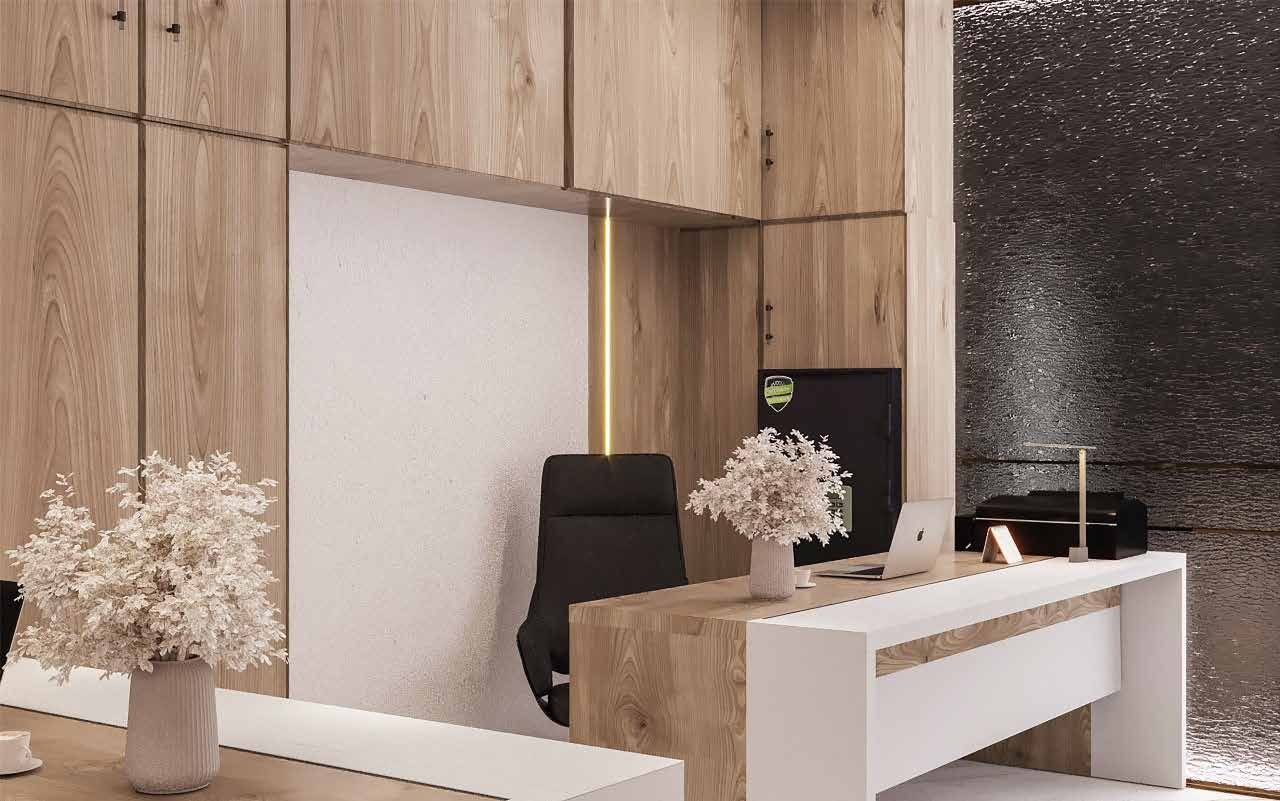 Completed office interior with oak-panelled walls and a white executive desk, delivered turnkey by Designation for Almadina Co. in Dammam
