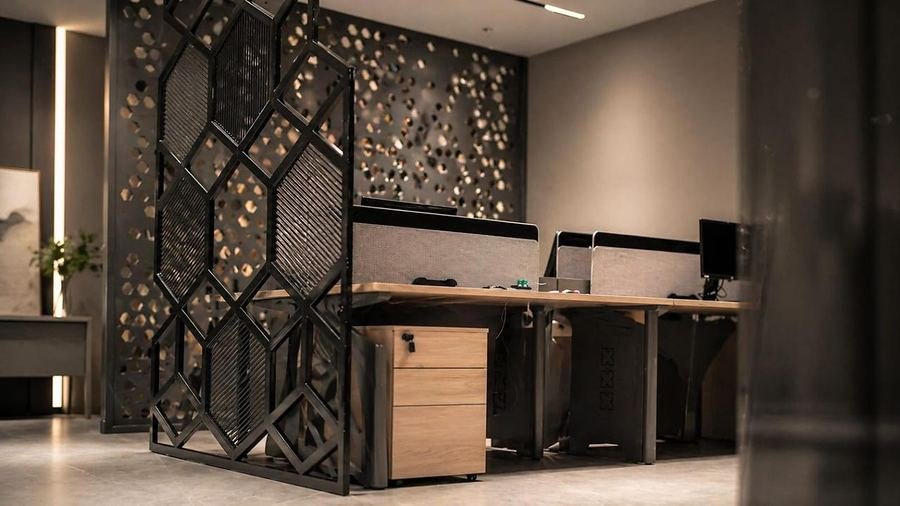 Laser-cut hexagonal metal screen dividing an office at Hixagone in Al Khobar