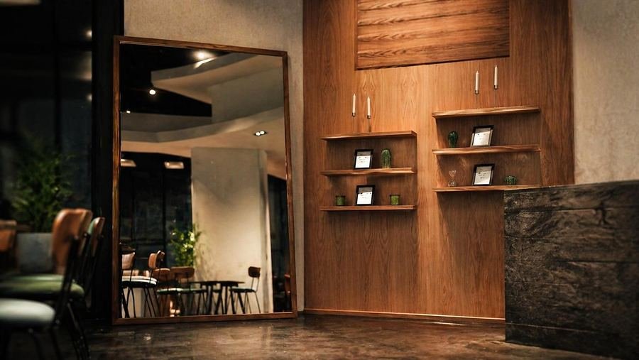 Restaurant interior with walnut feature wall and full-height mirror, fitted out for Wekad in Al Khobar